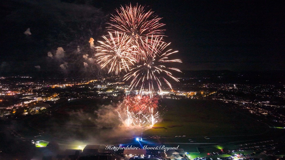 Aerial photograph of fireworks over a racecourse at night